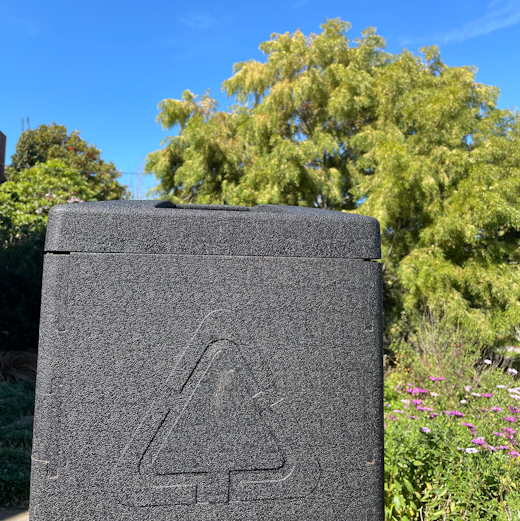 Bioverter unit in front of a clear blue sky and green trees.