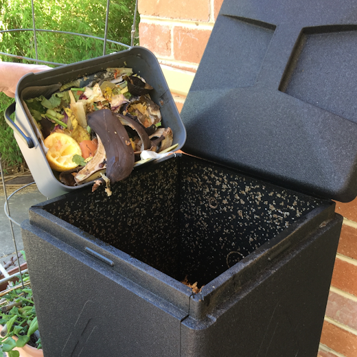 Food scraps from a kitchen caddy being poured into Bioverter.